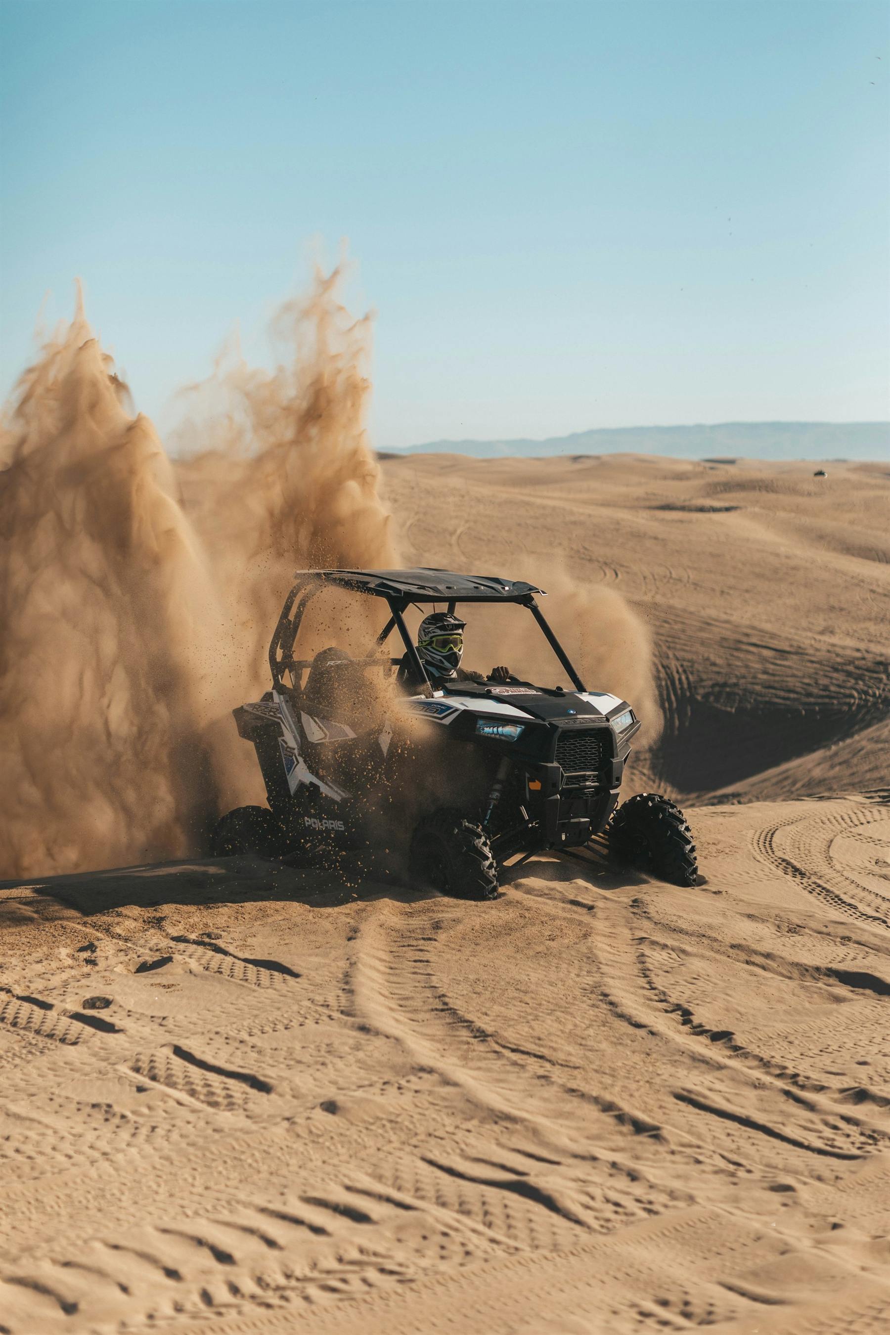 A buggy throwing up sand across the desert