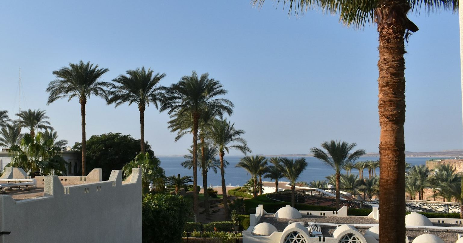 Sun loungers on a resort terrace above the Red Sea, with the Sinai mountains behind