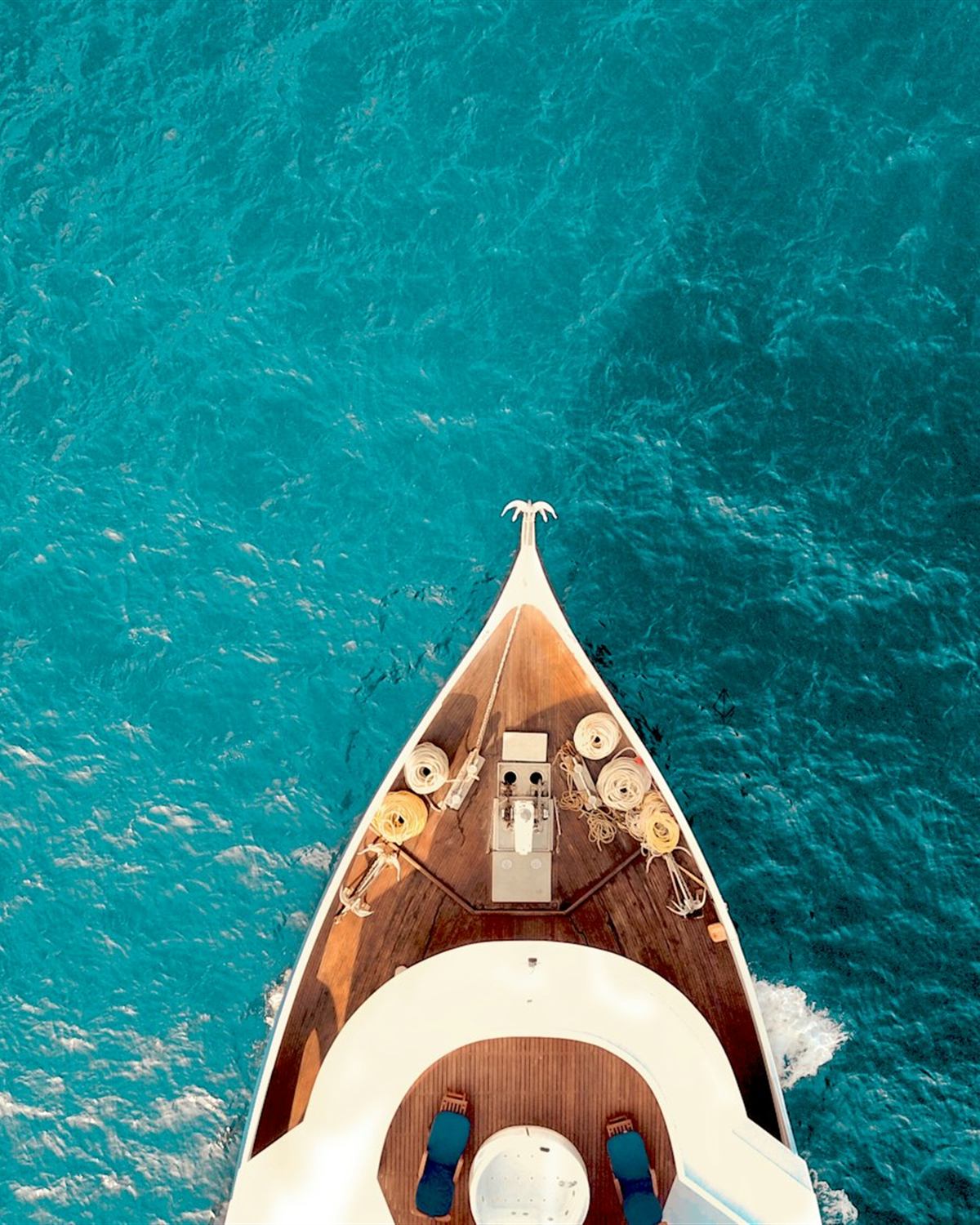 A boat on impossibly clear turquoise water, seen from above